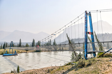 Mother and son hiking along a bridge crossing the South Saskatchewan River in the Nordegg Region of...
