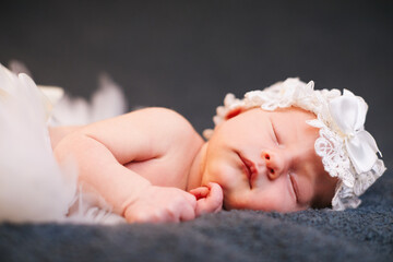 Obraz na płótnie Canvas Sleeping newborn baby wearing ballet tutu and headband.