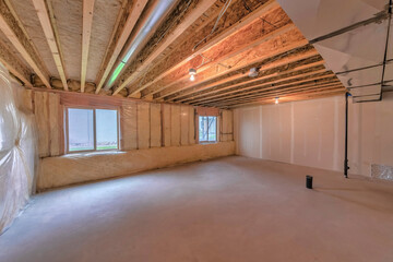 Unfinished basement with plastic vapor barrier and windows