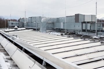 Solar panels with snow on the roof and air conditioning unit. - obrazy, fototapety, plakaty