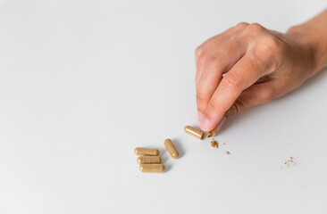 Close up hand with herb capsule on white background. Microdosing concept. Psychedelics therapy. Depression, anxiety treatment 