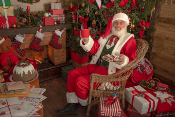 Santa Claus rejoicing with letters and mail in his post office indoors Log Cabin at the North Pole