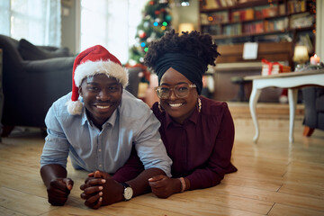 Fototapeta premium Young happy African American couple at home on Christmas day.
