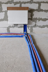 Metal heating radiator and water pipes in a country house under construction
