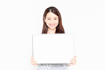 Naklejka premium 大きいスケッチブックを持って案内をするカジュアルな服を着ている女性