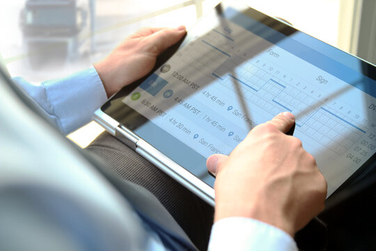 Safety manager is showing to Truck driver  th  electronic logbooks on a tablet