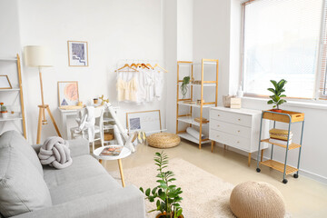 Interior of stylish room with modern workplace and clothes