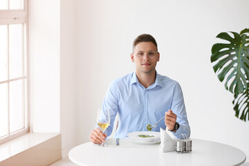 Fototapeta na wymiar Young man eating tasty ravioli in cafe