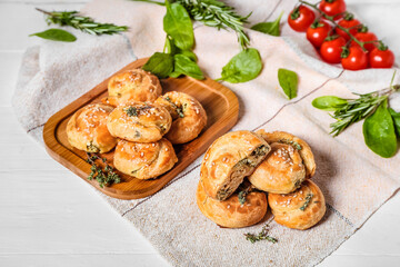 Puff pastry stuffed with spinach on white wooden background