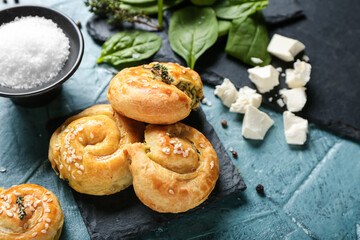 Puff pastry stuffed with spinach and feta cheese on color background