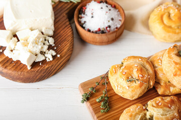 Puff pastry stuffed with spinach and feta cheese on white wooden background