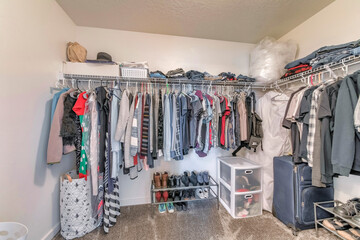 Interior of a small walk-in closet with wall mounted wire shelves