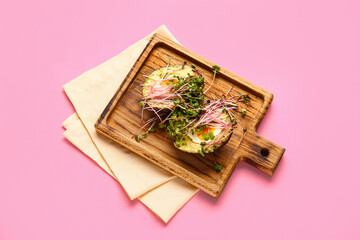 Tasty avocado with boiled egg and micro green on color background