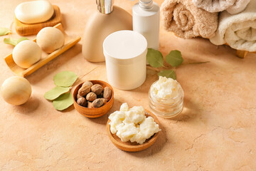 Composition with bowl of shea butter, nuts and bath supplies on color background