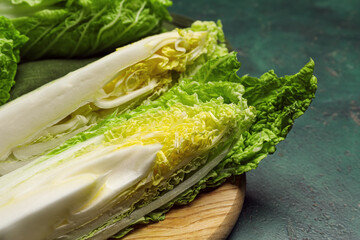 Board with fresh chinese cabbage on color background, closeup