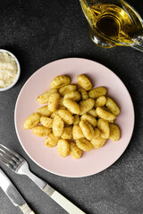 Composition with tasty pesto gnocchi on dark background