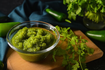 Bowl of Tomatillo Salsa Verde sauce on dark background