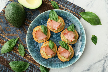 Tasty sandwiches with guacamole, ham and basil on white background