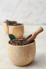 Bowls of dry hojicha green tea on light background