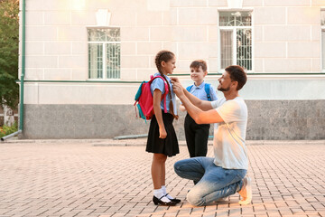 Cute little children going to school with their father