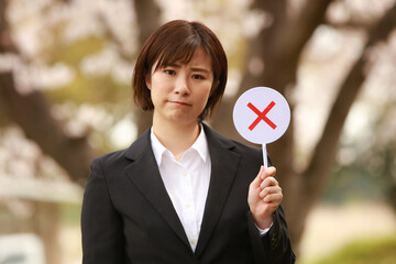 ×札を持つ女性社員