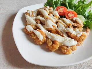 Fried shrimp butter with mayonnaise and Lettuce against a wooden background.