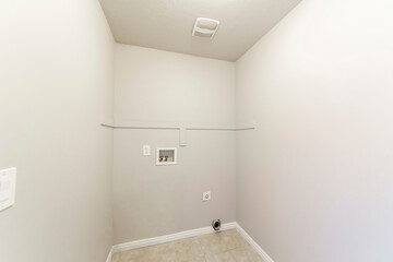 Tiled empty laundry room with hot and cold laundry connections