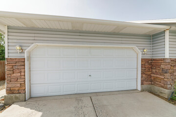 Sectional white clipped corner garage door with two wall lamps on the side