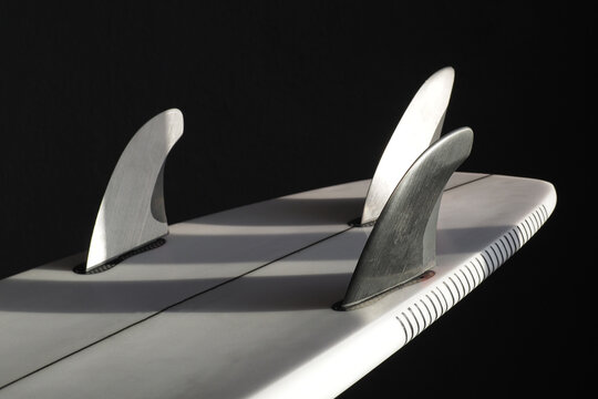 Modern carbon fibre fins on a surfboard. Close-up.