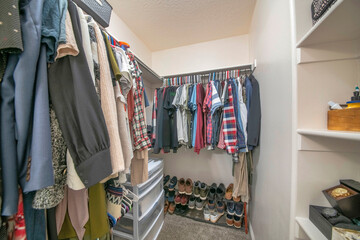 Hanging clothes on a metal rods inside a walk-in closet