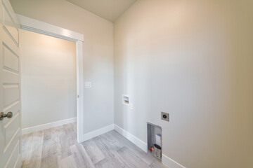 Empty laundry room with light beige interior and white wooden tiles
