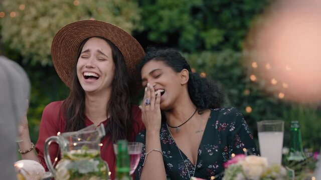 beautiful women friends celebrating at dinner party sitting at table making jokes laughing enjoying weekend reunion relaxing on beautiful summer evening outdoors 4k