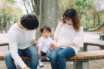 公園で両親と遊ぶ子供
