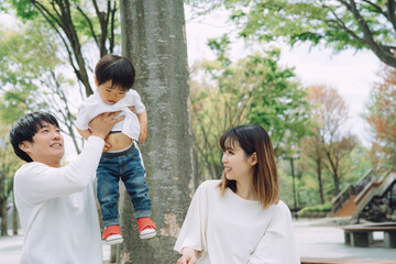 Obraz premium 公園で両親と遊ぶ子供 