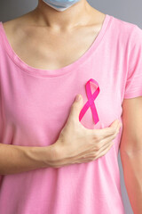 October Breast Cancer Awareness month, elderly Woman in pink T- shirt with hand holding Pink Ribbon...