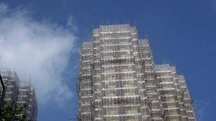 Tall high rise building in Hong Kong construction with whole bamboo scaffolding traditional regulation for refurbishment
