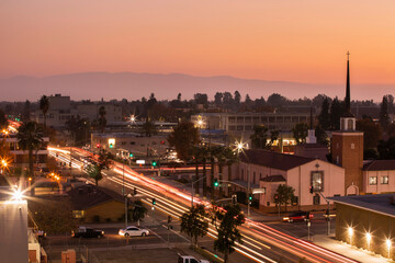 Fototapeta na wymiar Evening traffic streams through downtown Bakersfield, California, USA, at sunset.