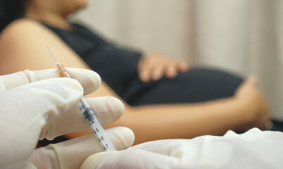 Obraz na płótnie Canvas doctor injects vaccine into pregnant woman