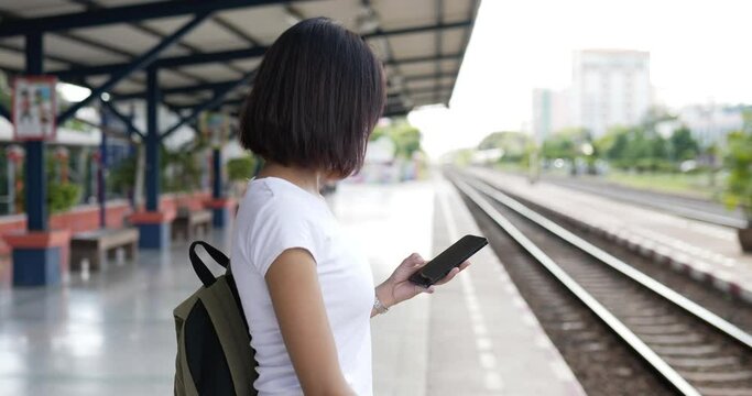 Woman waiting and selfie on phone the train at train station