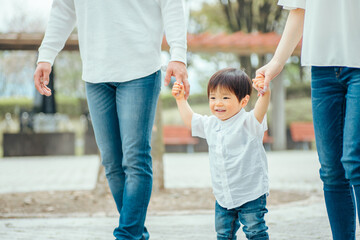 手を繋いで歩く家族
