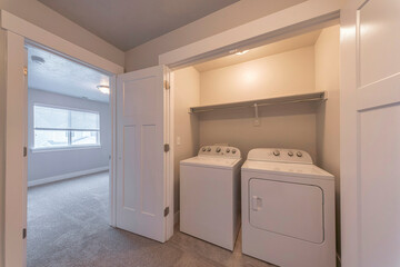Reach in laundry room interior with white bifold doors