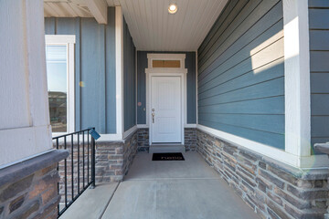 Entrance of a house with white front door and transom window with black doormat