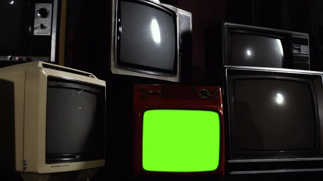Vintage Television Set Turning On Green Screen amidst a Pile of Retro TV. You can replace green screen with the footage or picture you want. You can do it with &ldquo;Keying&rdquo; effect in After Effects. 4K.