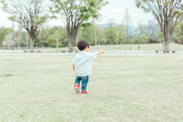 Fototapeta premium 公園で遊ぶ男の子（後ろ姿・顔なし） 