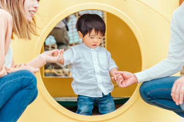 遊具で遊ぶ子供と両親
