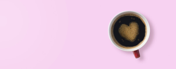 Top view of hot coffee latte with heart shaped latte art milk foam on pink pastel color sweet background.