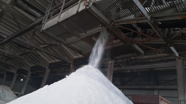 Ammonium sulfate powder pour in a pile inside a warehouse of chemical plant. Mineral organic fertilizers for agriculture industry.