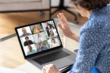 Online meeting, technology, brainstorming concept. Aged businesswoman using laptop for having virtual team meeting on video call with different people, work from home office or coworking