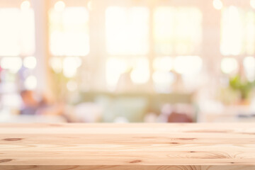 Wooden table top foreground with blurred indoor cafe shop and restaurant background for products display montage advertising banner.