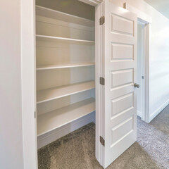 Square frame Linen closet of house with wide shelves for storing organization and white door